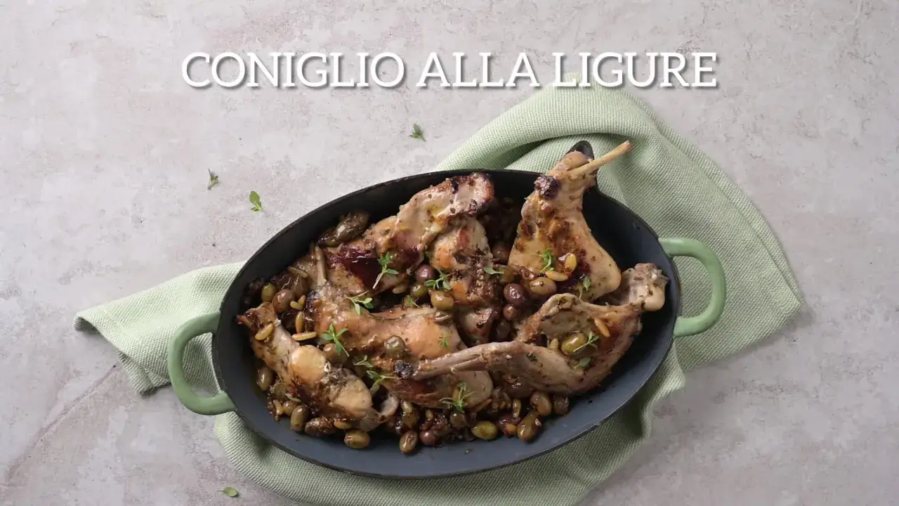 Un saporito coniglio alla ligure, cotto in tegame con olive, pinoli e erbe aromatiche, pronto per essere gustato.