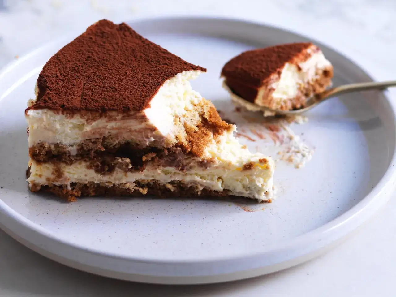 Fetta di tiramis&ugrave; ricetta originale, con savoiardi inzuppati nel caff&egrave; e crema al mascarpone, spolverata di cacao.