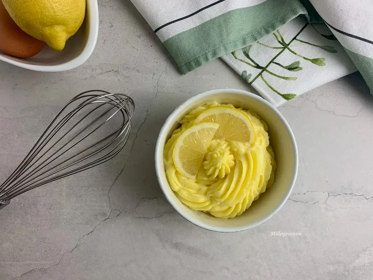 Crema pasticcera senza uova, soffice e profumata al limone, guarnita con fettine fresche. Ingredienti per una delizia vegana.