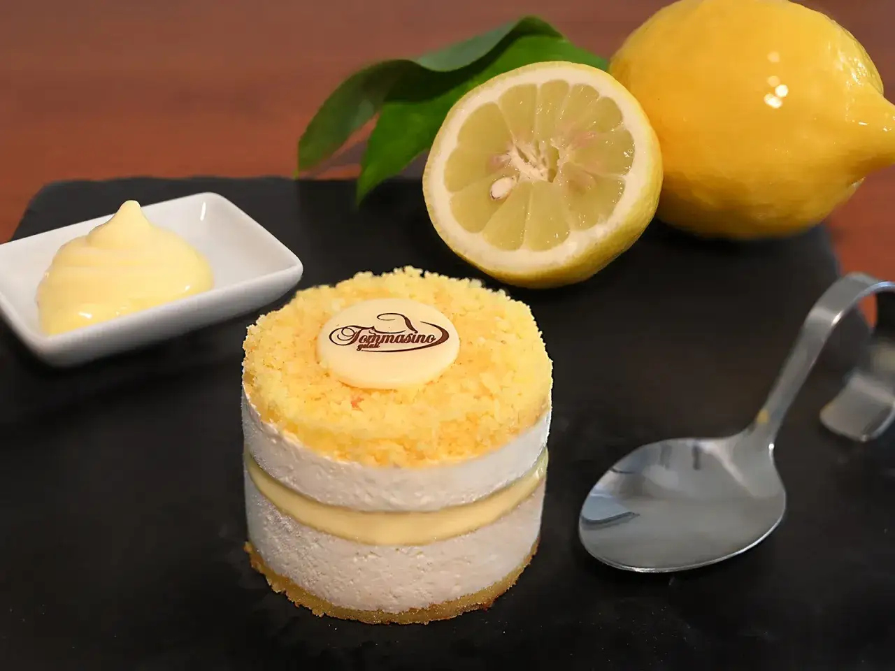 Delizioso semifreddo al limone con crema e pan di Spagna, guarnito con scorzetta gialla e un limone fresco.