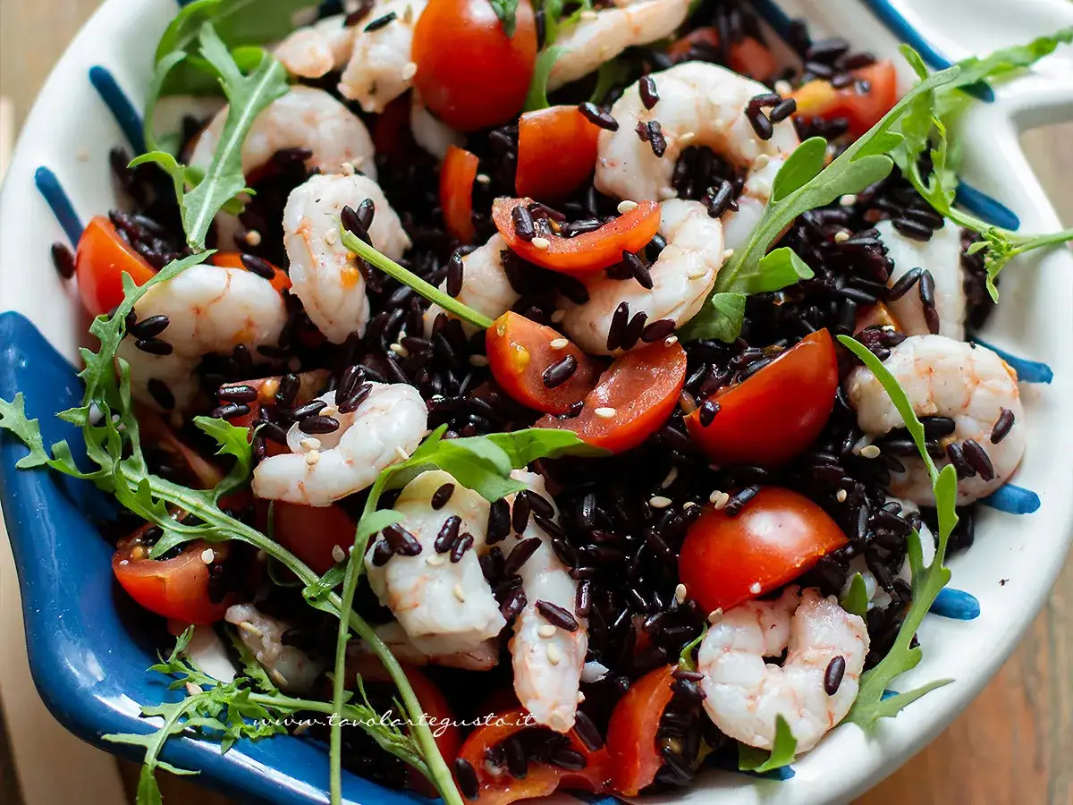Insalata colorata con riso venere, gamberetti succosi, pomodorini freschi e rucola croccante. Un piatto leggero e gustoso.
