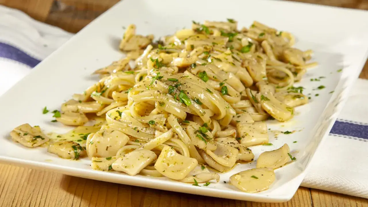Piatto di pasta con calamari, condita con erbe aromatiche e pepe nero. Un classico sapore di mare.
