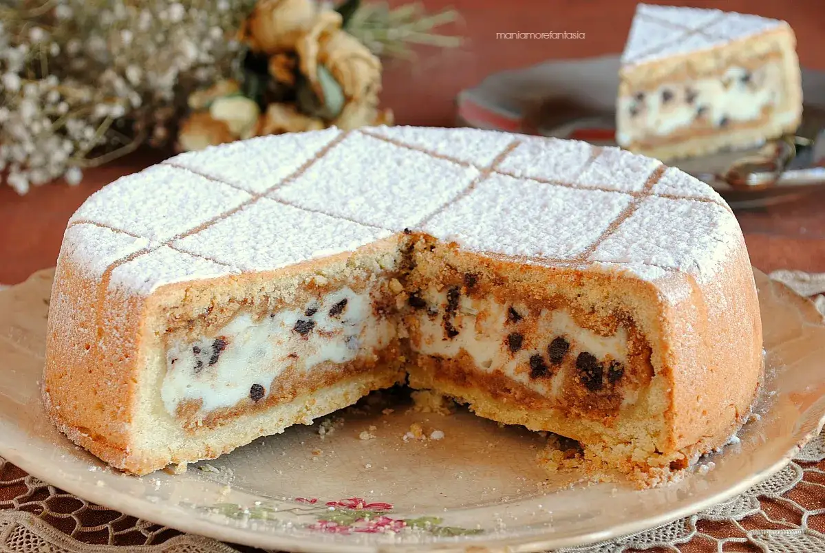 Una fetta di cassata al forno, con la sua golosa crema e gocce di cioccolato, spolverata di zucchero a velo.