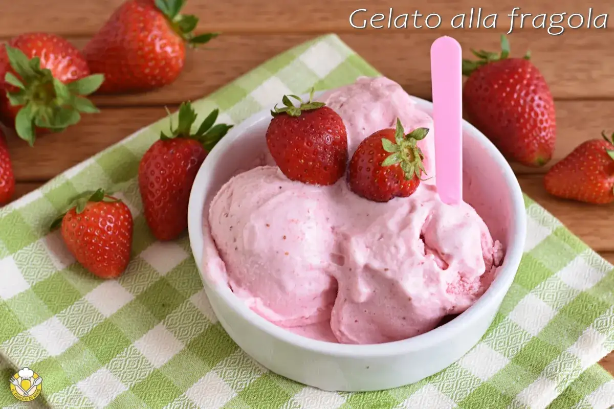 Un cremoso gelato alla fragola, guarnito con fragole fresche, su una tovaglietta a quadretti verdi.