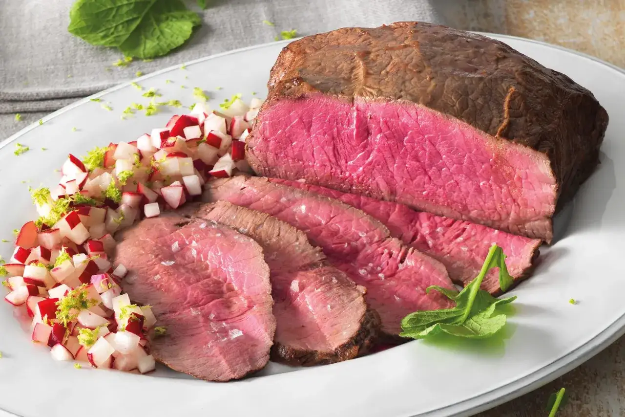 Roast beef ricetta: succulento arrosto di manzo affettato, servito con un contorno di ravanelli e scorza di lime.