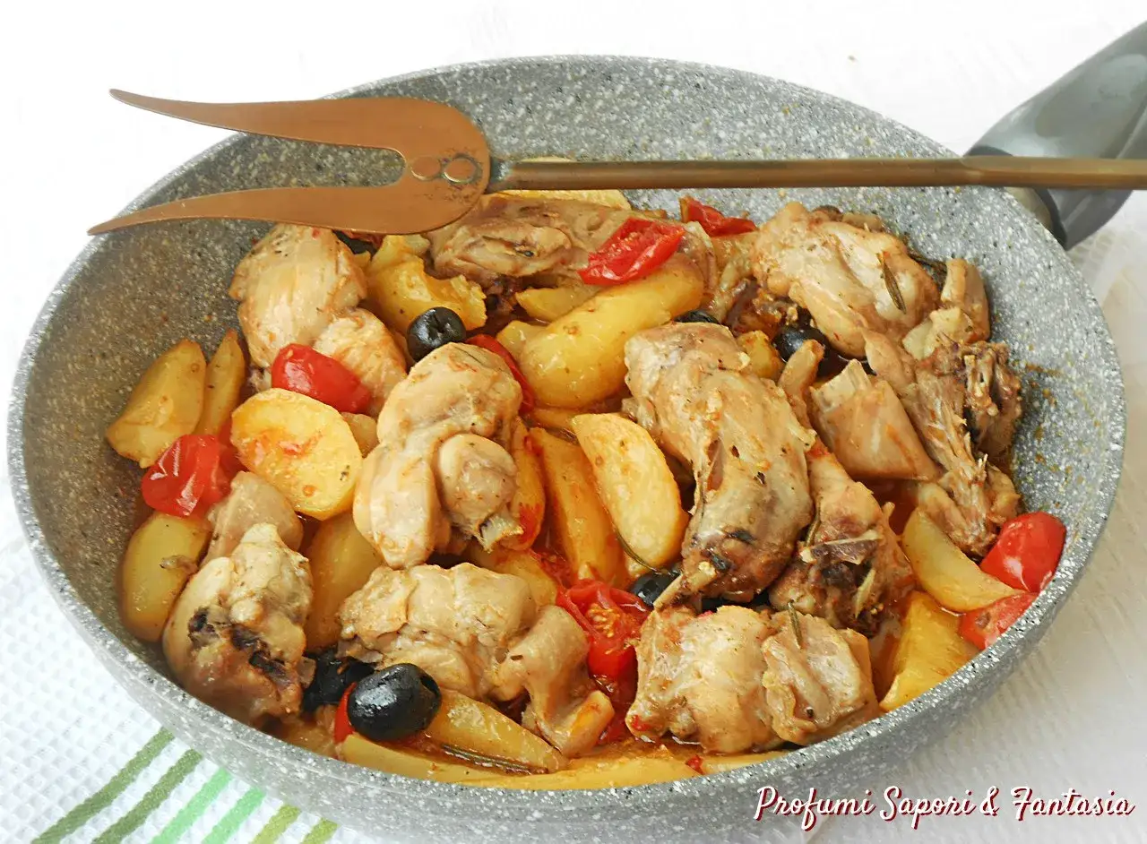 Un saporito coniglio alla cacciatora in padella con patate, pomodorini e olive nere.
