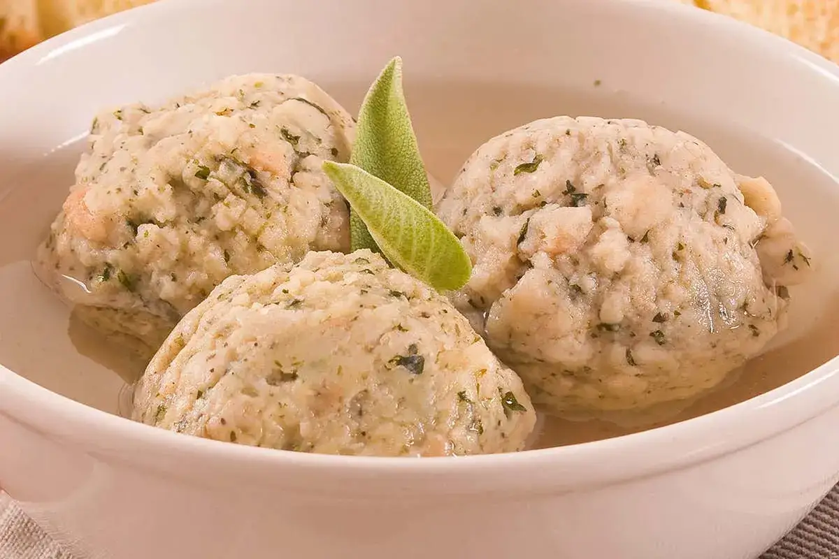 Tre soffici gnocchi di pane, profumati alle erbe, serviti in un brodo caldo con foglie di salvia.