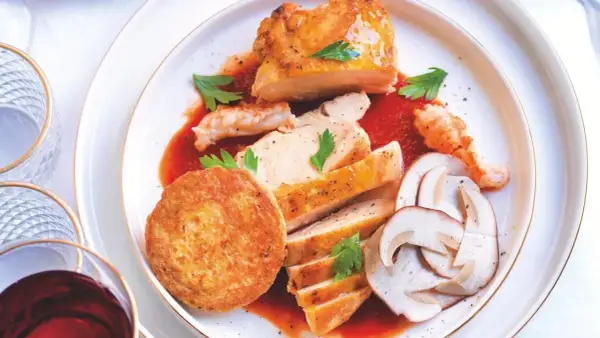 Piatto di pollo alla marengo con gamberi, funghi e tortino.