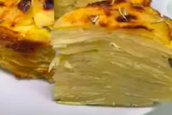 Un delizioso timballo di patate, con strati sottili e dorati, pronto per essere gustato.