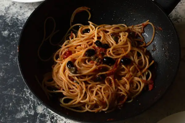 Spaghetti al sugo con olive nere e capperi, un piatto che sa di casa e di sapori intensi, quasi come una pasta con nduja.