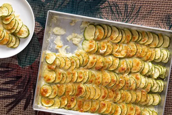 Fette di zucchine gratinate in teglia, un contorno di verdure dorato e invitante, pronto per essere gustato.