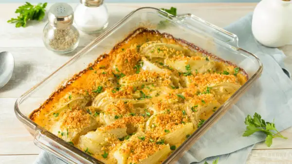 Finoçchi gratinati al forno, dorati e croccanti, con prezzemolo fresco. Un piatto invitante e saporito.