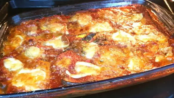 Parmigiana di melanzane non fritte appena sfornata, dorata e filante, pronta per essere gustata.