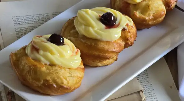 Zeppole di San Giuseppe: dolci fritti con crema pasticcera e ciliegina, un'esplosione di sapore.