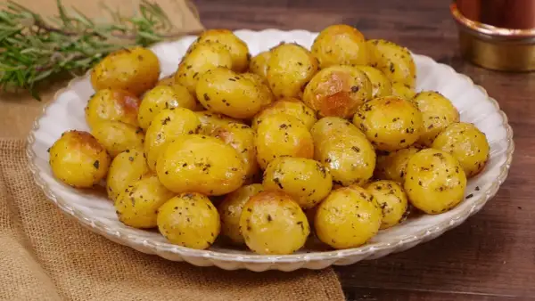 Un piatto invitante di patate novelle al forno, dorate e condite con erbe aromatiche, pronte per essere gustate.
